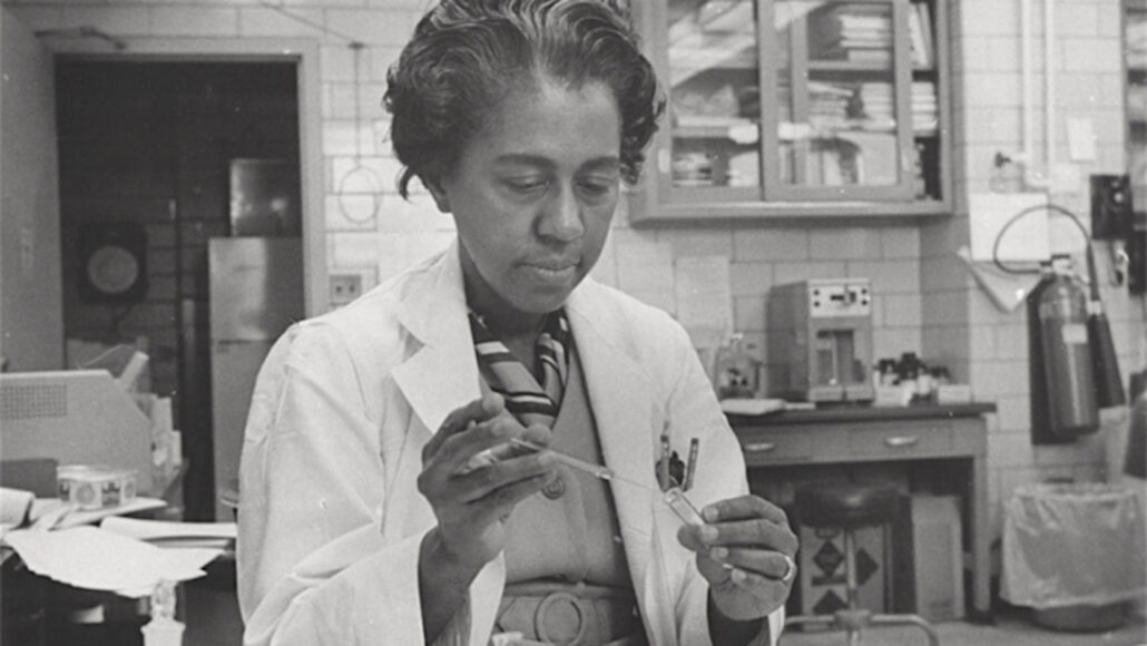 Marie Maynard Daly working in a lab with a test tube