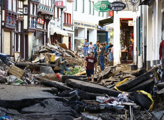 photo of people surveying debris in the streets of Euskirchen, Germany after a flood