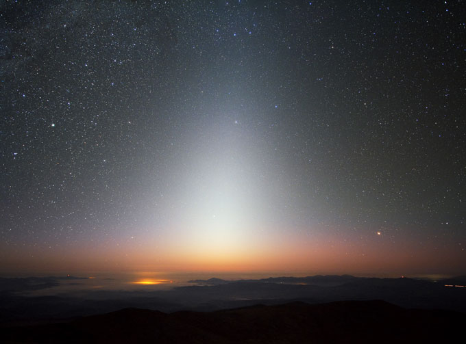 photo of a column of light above sunlight on the horizon taken at La Silla Observatory in Chile