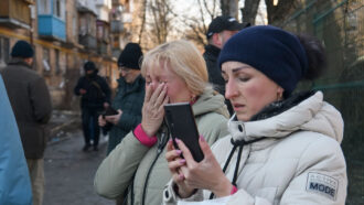 woman checking her phone in a crowd