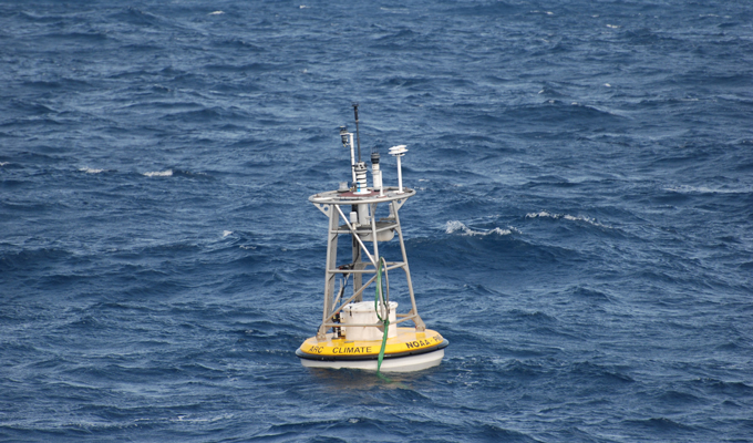 photo of a white and yellow NOAA buoy in the ocean southeast of South Africa