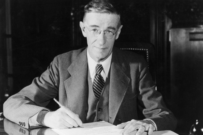 historical photo of Vannevar Bush holding a pencil to some papers