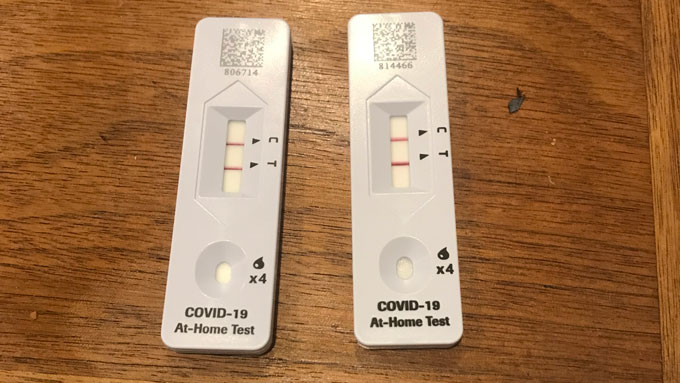 two positive COVID-19 at-home tests on a table