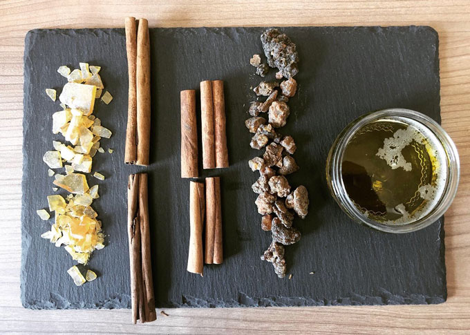 photo taken from above of pine resin, cinnamon cassia, true cinnamon, myrrh and moringa oil on a countertop