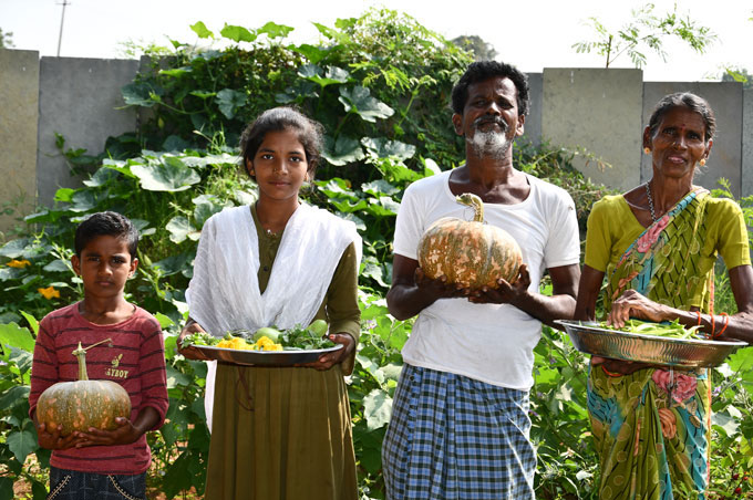 A family holding crops grown with natural farming methods