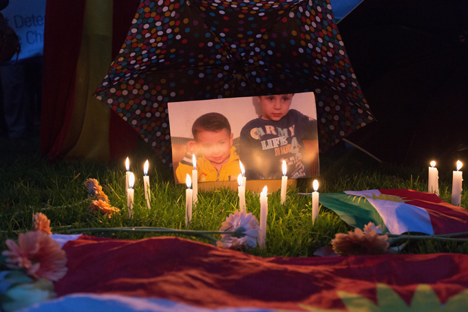 memorial with candles, flowers and a photo of Aylan Kurdi and his brother