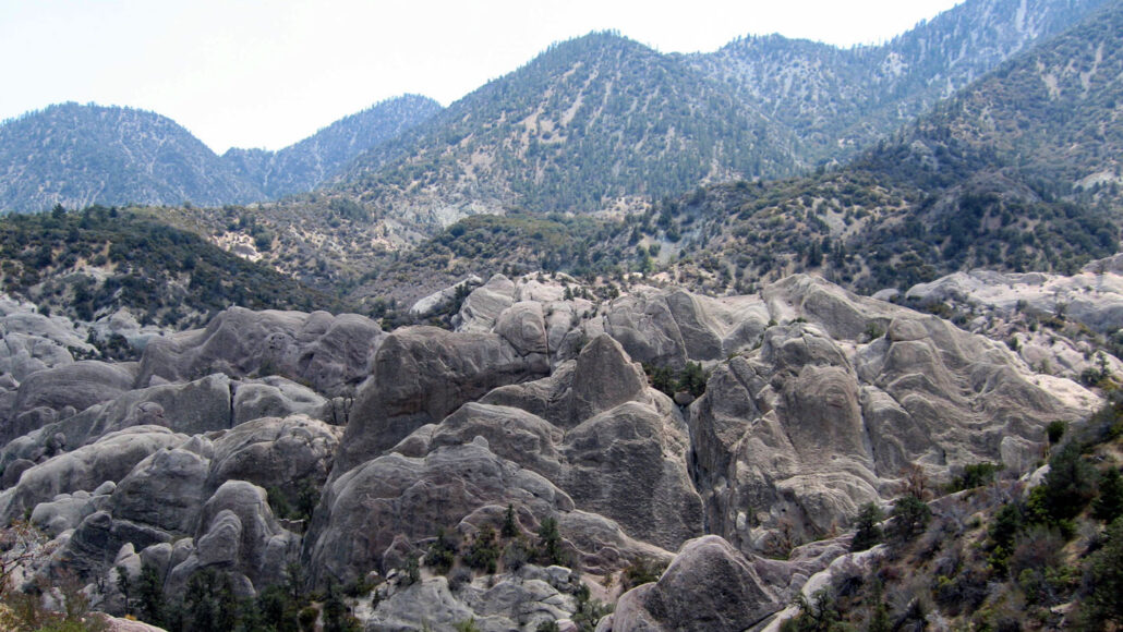 Rocks at the Devil’s Punchbowl geologic formation near Los Angeles, with mountains in the background