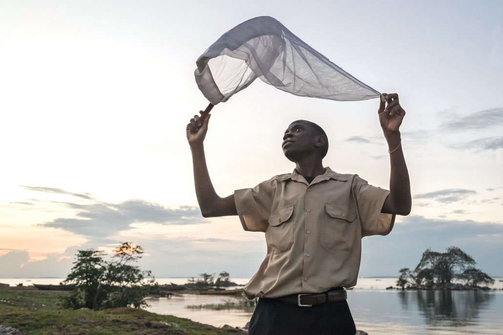 Victor Balyesima holds up a net to capture mosquitoes