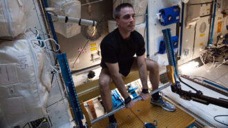 Astronaut Chris Cassidy lifts weights on the International Space Station.