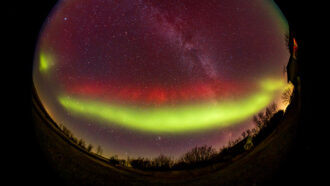 night sky photo of a double aurora (in green and red)
