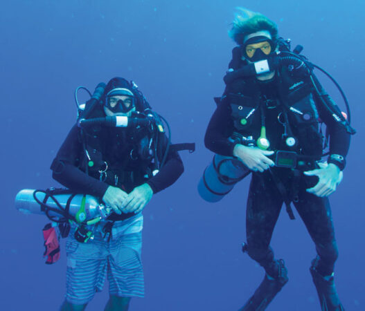 photo of Milton Carlo (left) and Evan Tuohy (right) scuba diving in the ocean