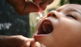 Photo of a child receiving an oral dose of a polio vaccine