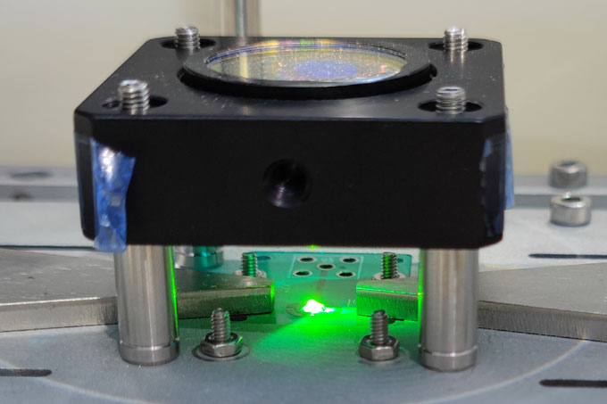 A prototype lens filters out green light from sunlight onto a diamond-based sensor below.