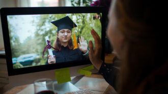 image of someone watching a woman graduate on a video call