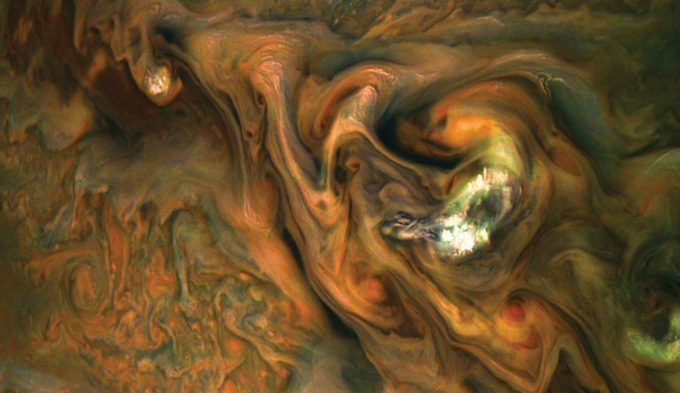 image of orange, white, green and brown clouds swirling in Jupiter's atmosphere