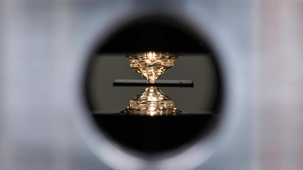photo of a room-temperature superconductor material being squeezed between two diamonds