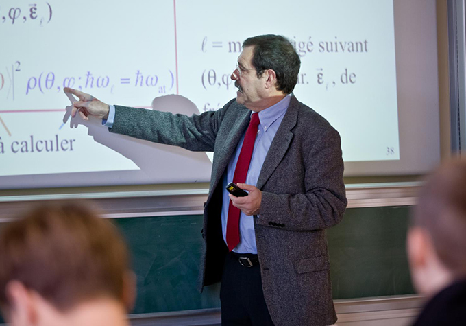 Alain Aspect points to an equation on a projection screen