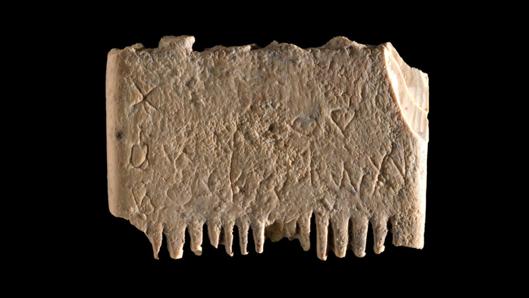 An ancient ivory comb with a row of teeth faint signs of engraving