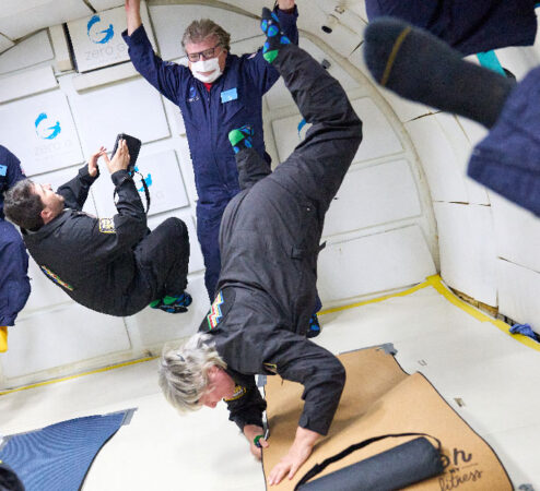 A woman floating upside down in the foreground while others float behind her