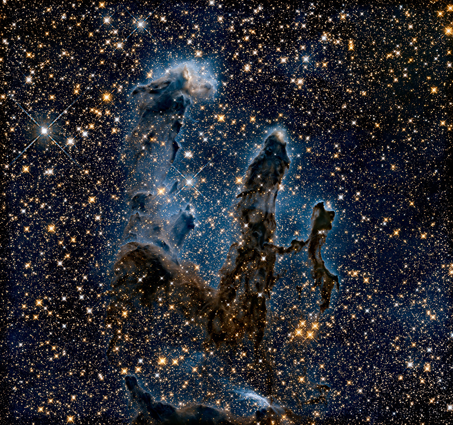 The Pillars of Creation are shown in infrared light, revealing more stars hidden by gas and dust.