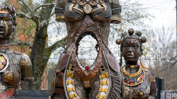 the "Mothers of Gynecology" monument, depicting three Black women. The woman depicted in the center of the photograph has a hollowed-out midsection. The two other figures, shown in the background, have jewelry typical of depictions of Africa