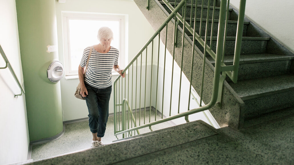 An older woman walking up stairs