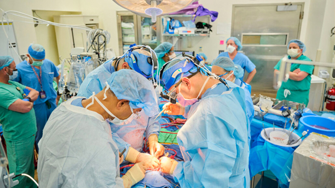 a photo of surgeons working to transplant a pig heart