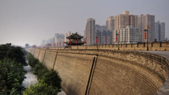 A photo of the Xi'an fortress wall with the city skyline visible in the background.
