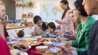 A large family sits around a table sharing a meal.