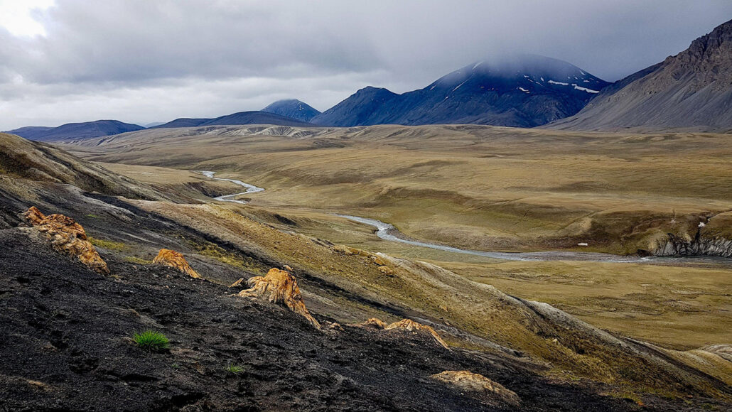 A wide photo of a valley on Ellesmere Island in Canada with mountains in the background.