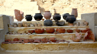 rows of pots and other vessels used in an Egyptian embalming workshop seen in an archaeological site