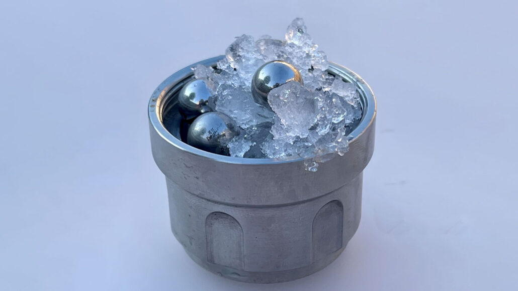 A metal vessel filled with ice and stainless steel balls