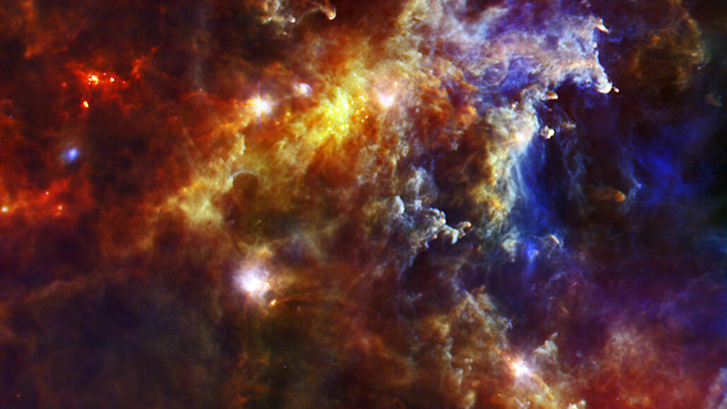 the Rosette Nebula, shown as a dense cloud of red, yellow, orange and blue, with bright white spots