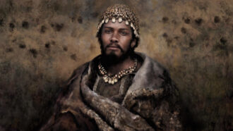 An artistic portrayal of a southeastern European hunter-gatherer from the Gravettian culture. The man has dark skin and dark hair. He is wearing a skull cap, necklace and a fur shawl.