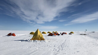 A photo of several tents set up on in Antarctica.