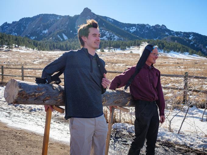 Two men give their heads a break by resting their timber on T-shaped wooden sticks.