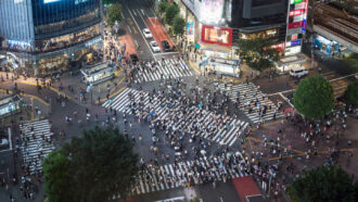 An overhead photo of several pedestrian intersections with lots of people walking through the area.