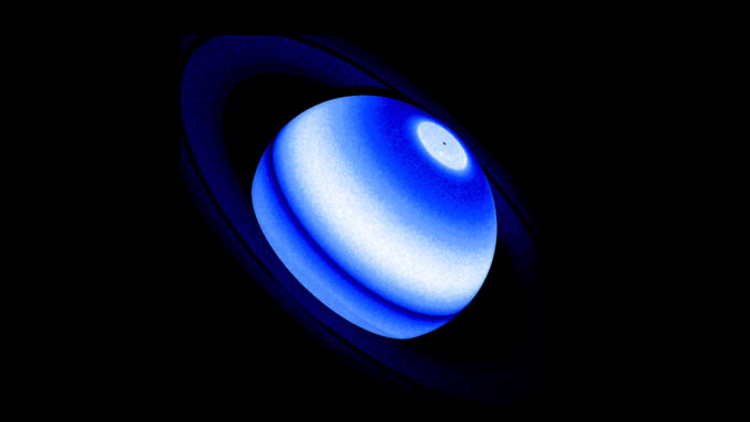An ultraviolet composite image of Saturn. The planet is seen in shades of blue with a white band towards the center at at the top.