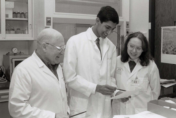 Raj Chetty stands in a lab with Vladimir M. Kushnaryov and an unnamed female scientist