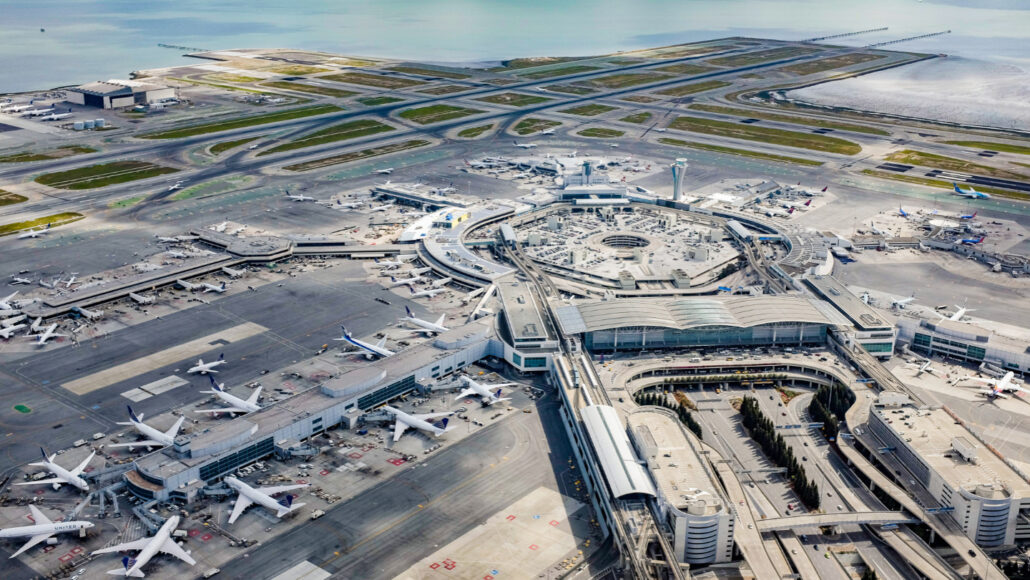 A wide shot photo of San Francisco International Airport with planes at several gates and runways visible in the distance.