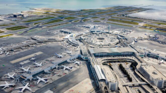 A wide shot photo of San Francisco International Airport with planes at several gates and runways visible in the distance.