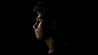 A photo of a teen boy's profile with the light shining just on his face.