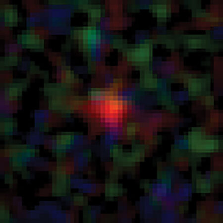 A James Webb Space Telescope image of Maisie's Galaxy, which appears as a series of red pixels surrounded by clumps of blue, green and brown pixels.