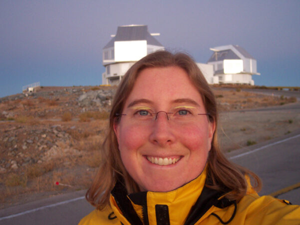 A photo of Jane Rigby standing in front of the Las Campanas Observatory in Chile.