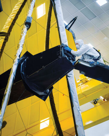 Larkin Carey removes the cover that kept the James Webb Space Telescope's instruments safe from contaminants and stray light.