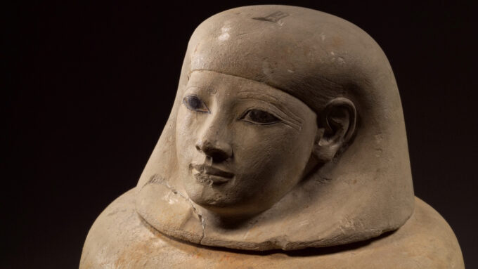 A jar with a top that shows the facial likeness of an Egyptian woman holds the viscera of a woman named Senetnay.