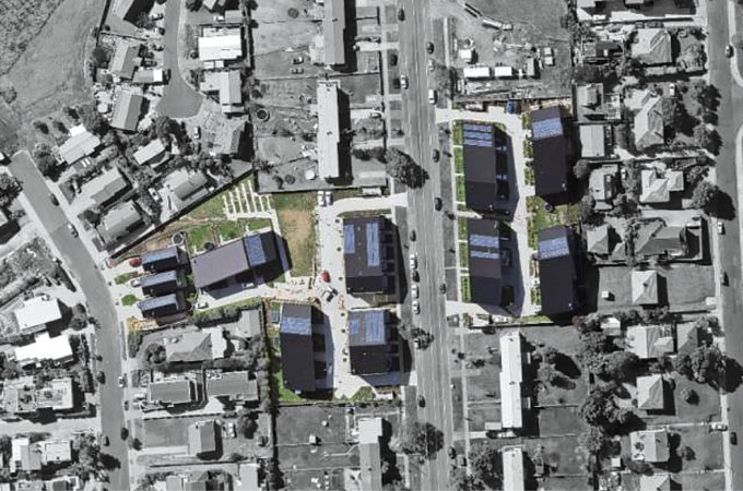 An overhead view of a community in Auckland, New Zealand. An area in the middle is colorized while areas on the outer edges are in black and white.