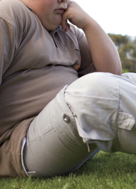 overweight boy sits alone