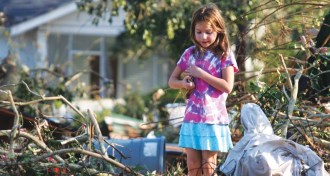 girl standing in wreckage of Hurricane Katrina