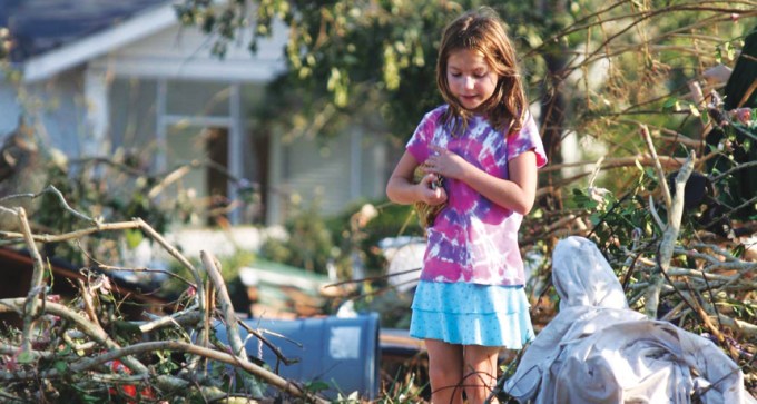 girl standing in wreckage of Hurricane Katrina